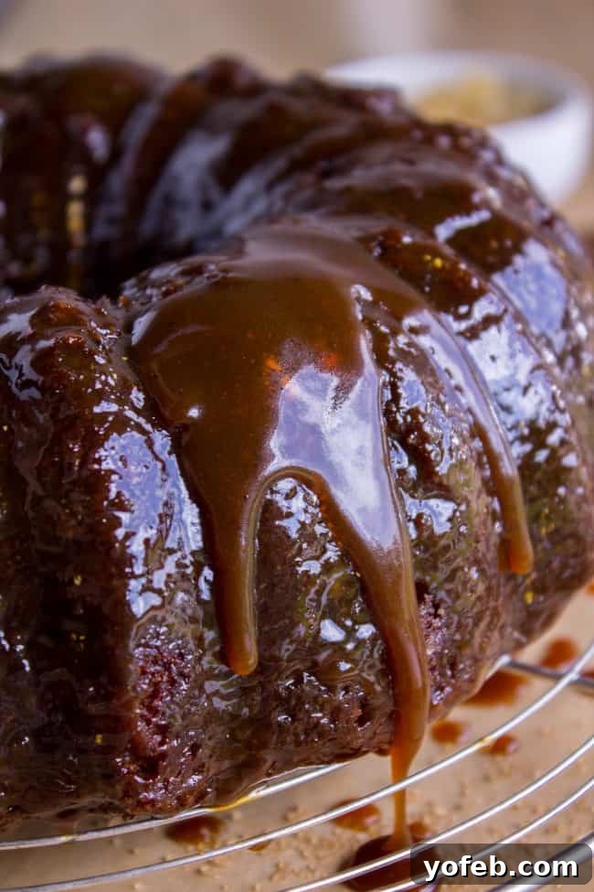 Ginger Sticky Toffee Pudding Cake from The Food Charlatan. This is a classic English dessert! The chopped dates make it incredibly moist as is, but then we go and dump buttery caramel sauce all over the top of it while it's warm. It's ridiculous and you will love it! #cake #pudding #english #englishpudding #toffee #sticky #ginger #recipe #easy #baked #dates #traditional #holidays #thanksgiving #Christmas #fall #fallbaking #spice #spicecake #caramel #caramelsauce Generously sauced Ginger Sticky Toffee Pudding Cake