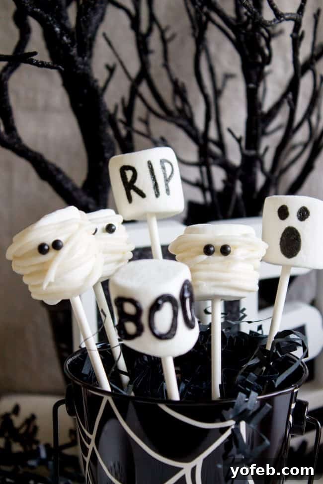 Diverse Halloween Marshmallow Pops: Frankenstein, Mummy, and Ghost designs. A festive trio of Halloween marshmallow pops including a green Frankenstein with black hair, a white mummy with icing bandages, and a white ghost with simple black eyes, against a spooky, dark backdrop with spiderweb details.