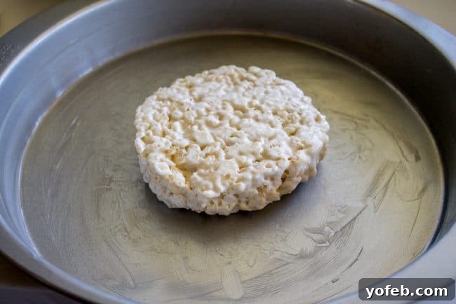 Releasing Candy Corn Rice Krispie Treats from Pan A hand peeling a perfectly shaped Candy Corn Rice Krispie Treat from a cake pan.