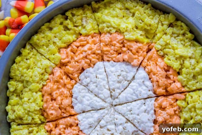 Layered Candy Corn Rice Krispie Treat Circle A close-up of a completed round Rice Krispie Treat cake, showing the concentric white, orange, and yellow layers before cutting.