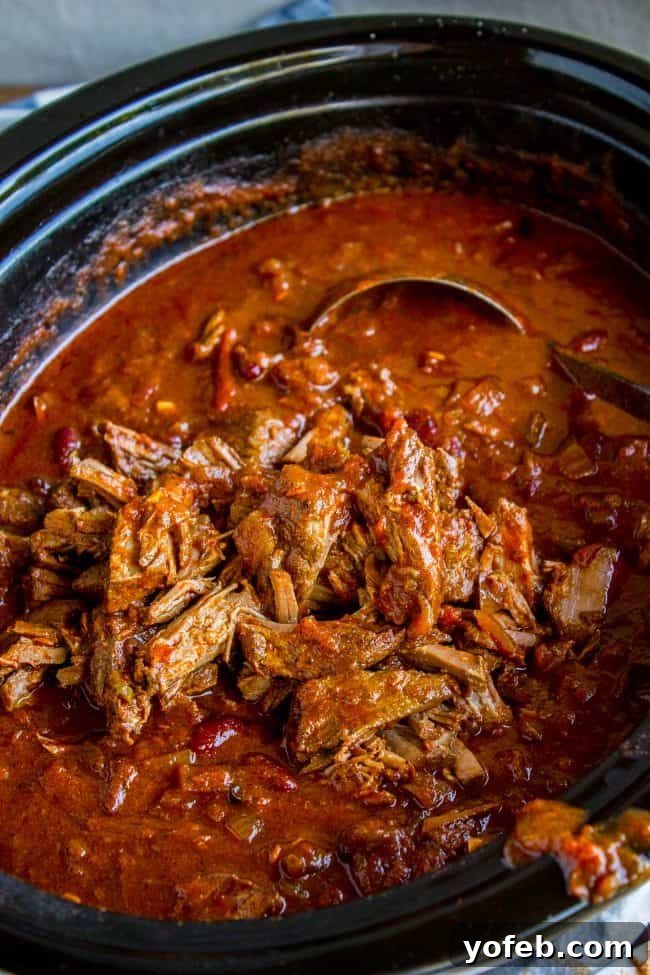 Slow Cooker Chili with Shredded Beef and Beans - Simmering to perfection. Hearty slow cooker chili with tender shredded beef and kidney beans, ready for a ladle, showcasing the rich texture and deep color.