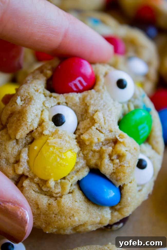 Soft and Chewy Monster Cookies Close-up shot of a perfectly baked, soft monster cookie with M&Ms and candy eyes.