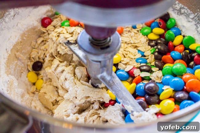 Mixing dough with mix-ins Mixing colorful M&Ms and oats into rich cookie dough.