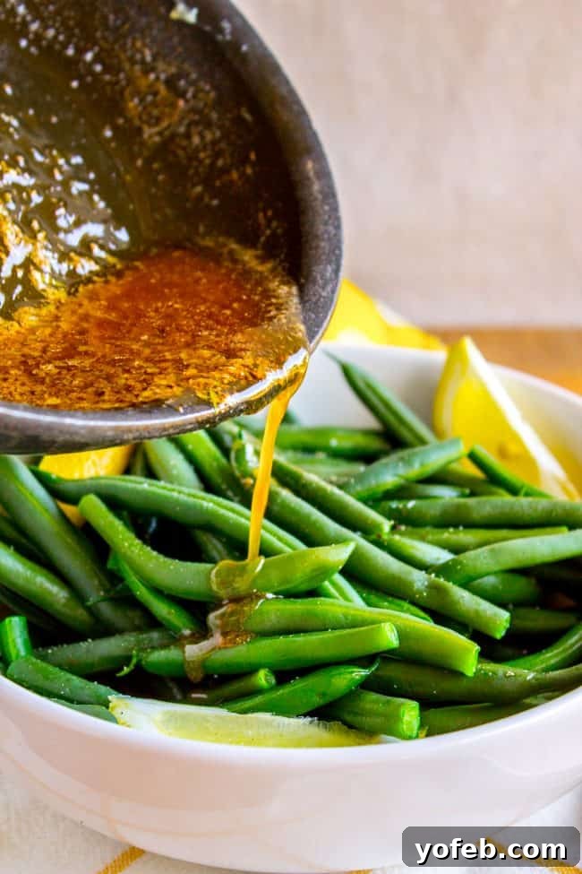 Bright Lemon Almond Green Beans 9 Rich browned butter being poured over a bed of blanched green beans.