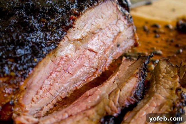 How to Cook Tri Tip (Grilled or Oven-Roasted) from The Food Charlatan. If you've never had tri tip, you haven't lived! I will show you how to cook tri tip on the grill or in the oven. It's SO easy and the flavor is unbeatable! We always had tri tip for Christmas dinner growing up, it's an impressive holiday dinner! #intheoven #grilled #garlic #recipes #marinade #dinner #bbq #howtocook #rub #sandwich #santamaria #seasoning #steak #baked #roast #Christmas #Thanksgiving #Easter #beef #best A perfectly cooked medium-rare tri-tip steak with a crispy, blackened top layer, ready for slicing.