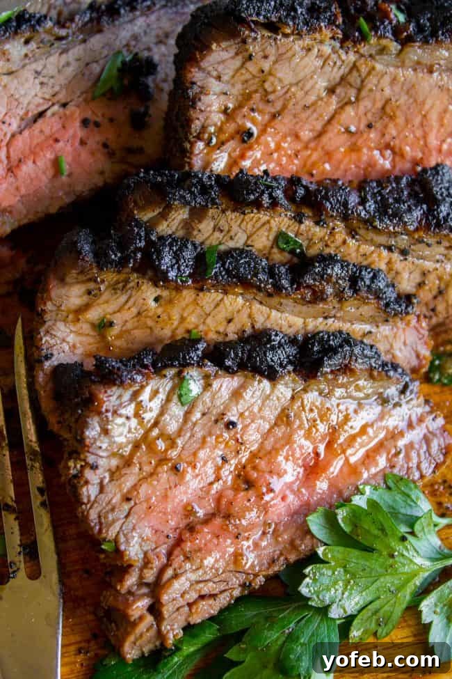 How to Cook Tri Tip (Grilled or Oven-Roasted) from The Food Charlatan. If you've never had tri tip, you haven't lived! I will show you how to cook tri tip on the grill or in the oven. It's SO easy and the flavor is unbeatable! We always had tri tip for Christmas dinner growing up, it's an impressive holiday dinner! A garlic marinade rub and tri tip roast recipe for a Christmas meal or summer bbq? Yes, please! All the tender, juicy, beefy goodness of steak but at a much more affordable price. Close-up of perfectly sliced medium-rare tri-tip with visible juices, showcasing the successful outcome of the cooking process.