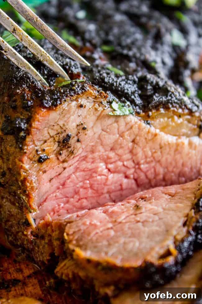 How to Cook Tri Tip (Grilled or Oven-Roasted) from The Food Charlatan. If you've never had tri tip, you haven't lived! I will show you how to cook tri tip on the grill or in the oven. It's SO easy and the flavor is unbeatable! We always had tri tip for Christmas dinner growing up, it's an impressive holiday dinner! A garlic marinade rub and tri tip roast recipe for a Christmas meal or summer bbq? Yes, please! All the tender, juicy, beefy goodness of steak but at a much more affordable price. A slice of medium-rare tri-tip steak, pierced by a fork, showcasing its juicy, tender texture.