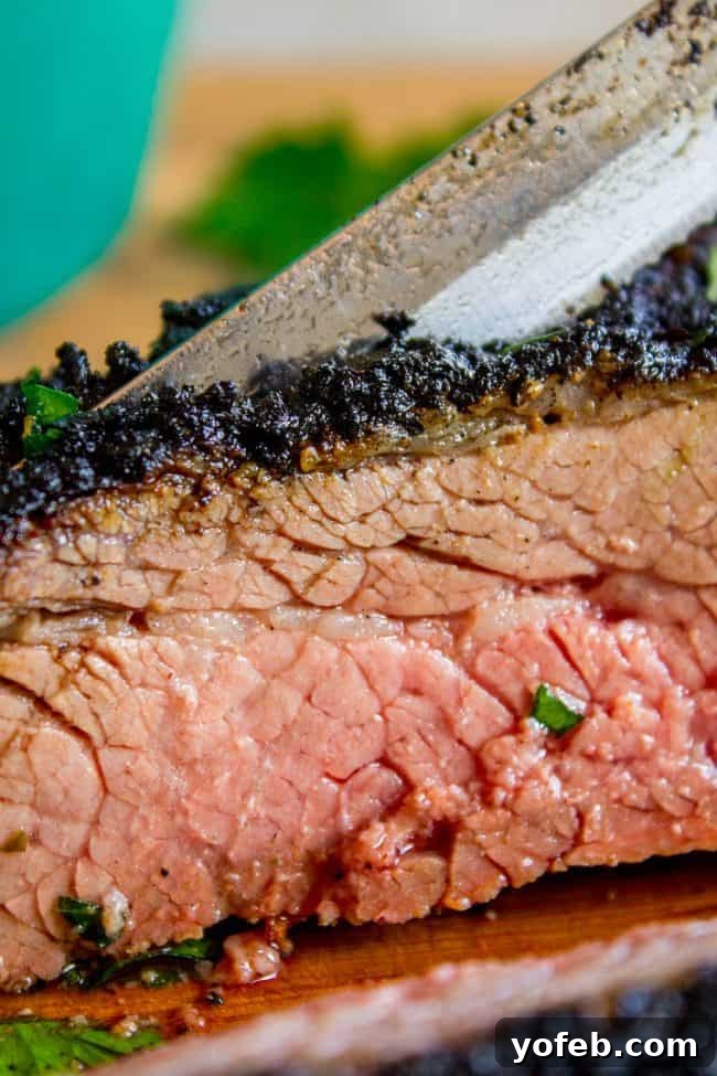 How to Cook Tri Tip (Grilled or Oven-Roasted) from The Food Charlatan. If you've never had tri tip, you haven't lived! I will show you how to cook tri tip on the grill or in the oven. It's SO easy and the flavor is unbeatable! We always had tri tip for Christmas dinner growing up; it's an impressive holiday dinner! A garlic marinade rub and tri tip roast recipe for a Christmas meal or summer bbq? Yes, please! All the tender, juicy, beefy goodness of steak but at a much more affordable price. A sharp knife begins to slice into a perfectly cooked tri-tip roast, revealing its tender, juicy interior.