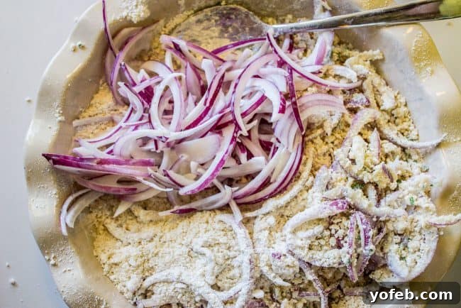 Coating Onions for Perfect Fried Crunch Coating red onion slices in a flour and Panko mixture in a pie pan.