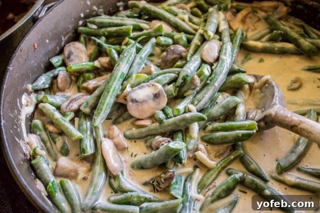 Ready to Bake: Green Bean Casserole Base A delectable mixture of green beans, Parmesan cheese, and creamy mushroom sauce ready for baking.