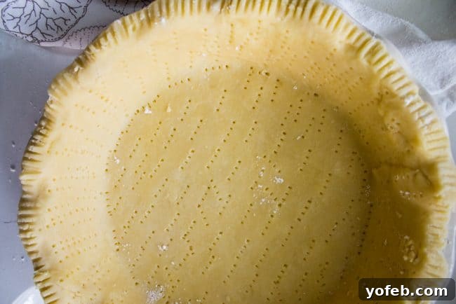 A butterscotch pie with its golden crust, creamy filling, and fluffy white meringue, ready for a final bake or torching.