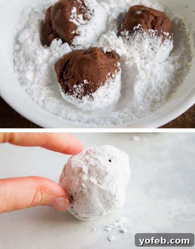 Hands rolling chocolate cookie dough in a bowl of powdered sugar, showing the process of creating the crinkled texture.