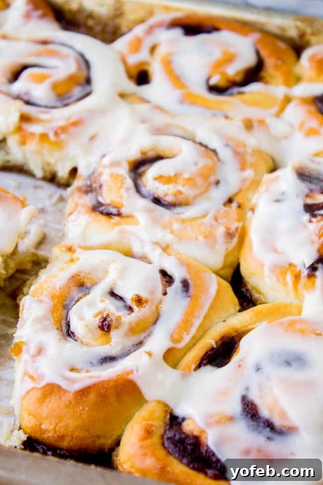 A baking pan filled with frosted homemade cinnamon rolls, showcasing their golden-brown tops and generous icing.
