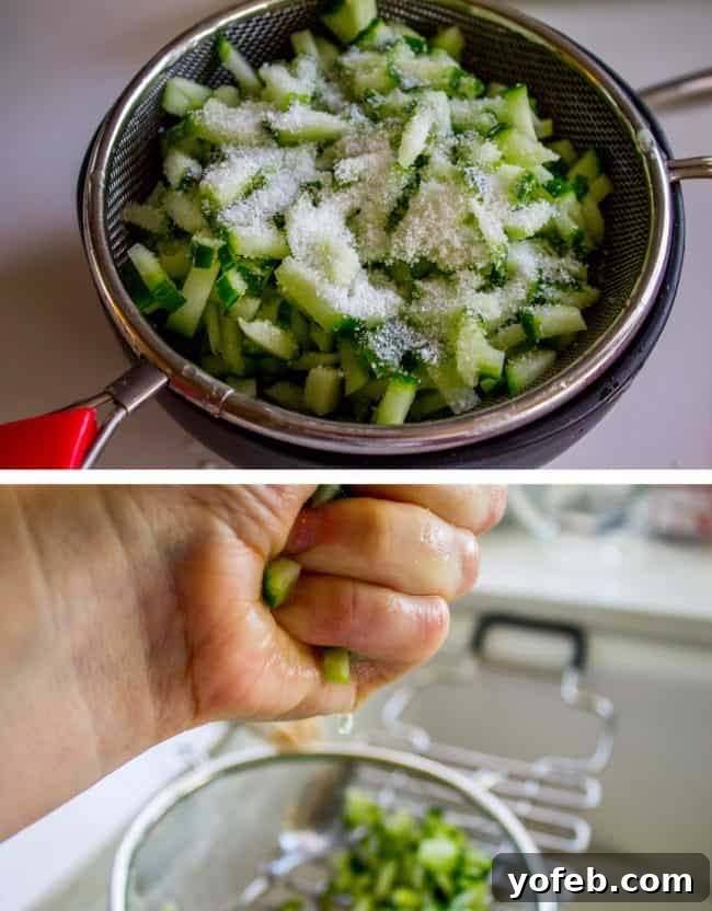 Refreshing Tzatziki with Warm Zaatar Pita Chips 4 A hand squeezing water out of salted chopped cucumbers in a mesh strainer for tzatziki sauce.