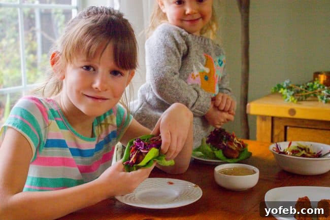 Kids enjoying healthy and delicious Thai Lettuce Wraps. two cute kids eating Thai lettuce wraps.