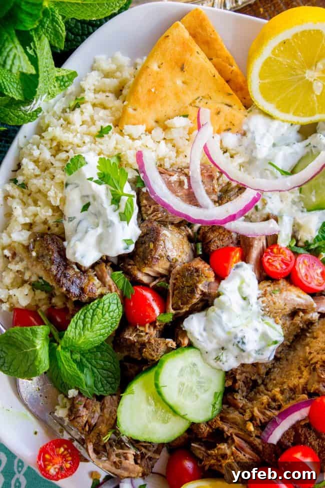 Homemade Shredded Beef Gyros: A healthy, flavorful Greek feast with Instant Pot or Crock Pot ease. Flavorful shredded gyro beef with cauliflower rice, creamy tzatziki sauce, toasted pita bread, and a medley of fresh vegetables and herbs.