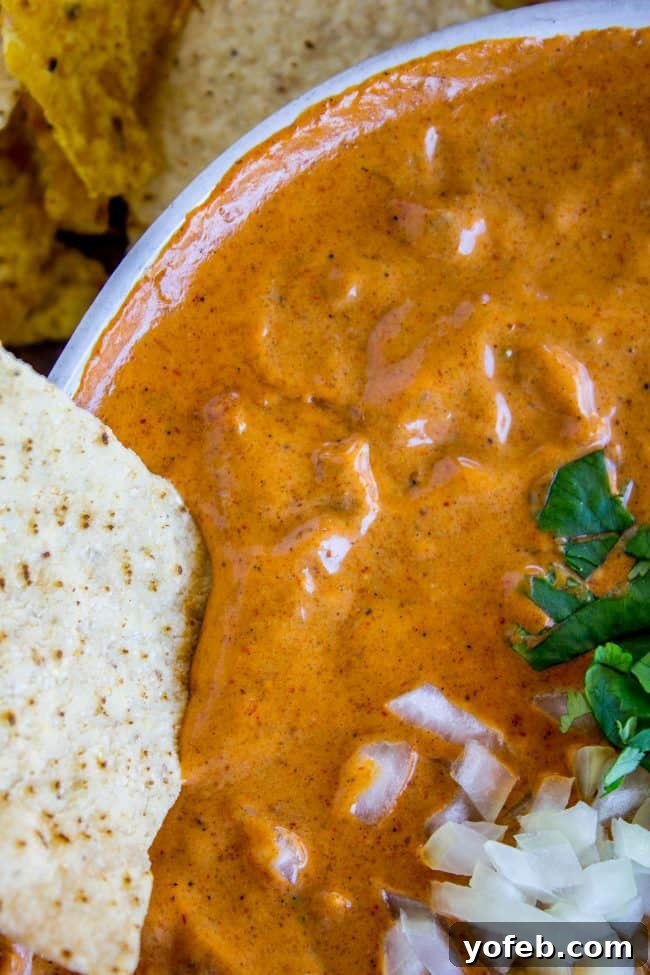 Copycat Chili's Queso Dip (Slow Cooker) Three small bowls of chili's copycat queso dip, garnished with chopped cilantro and lime wedges, inviting guests to dig in.