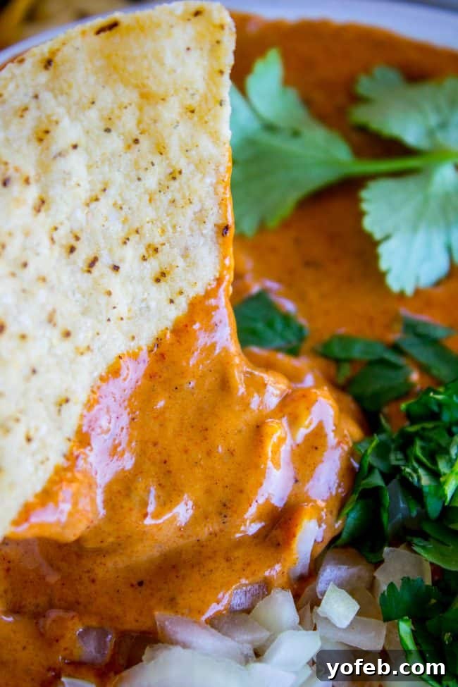 Copycat Chili's Queso Dip (Slow Cooker) The finished Chili's copycat queso dip bubbling gently in a slow cooker, maintaining its warm, creamy texture for easy serving.