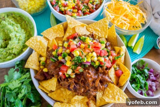 Stacked Chili Nachos with Molten Queso and Fresh Guacamole 5 A vibrant plate of loaded chili nachos with a variety of toppings.