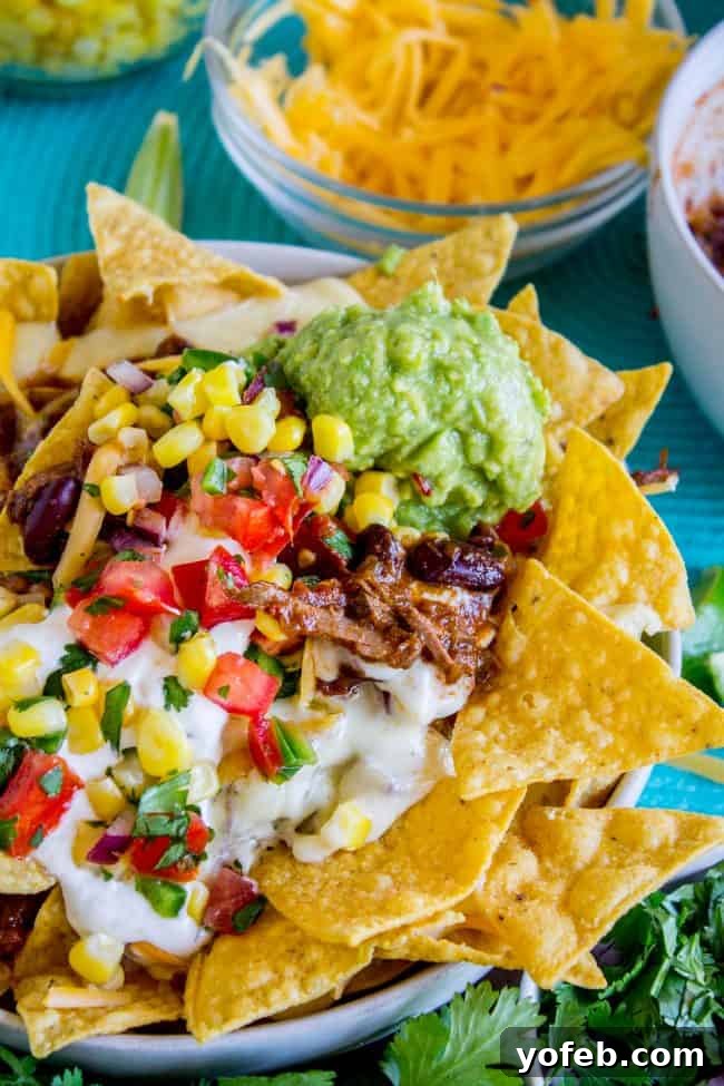 Stacked Chili Nachos with Molten Queso and Fresh Guacamole 7 Chili cheese nachos close-up, highlighting the shredded beef chili.