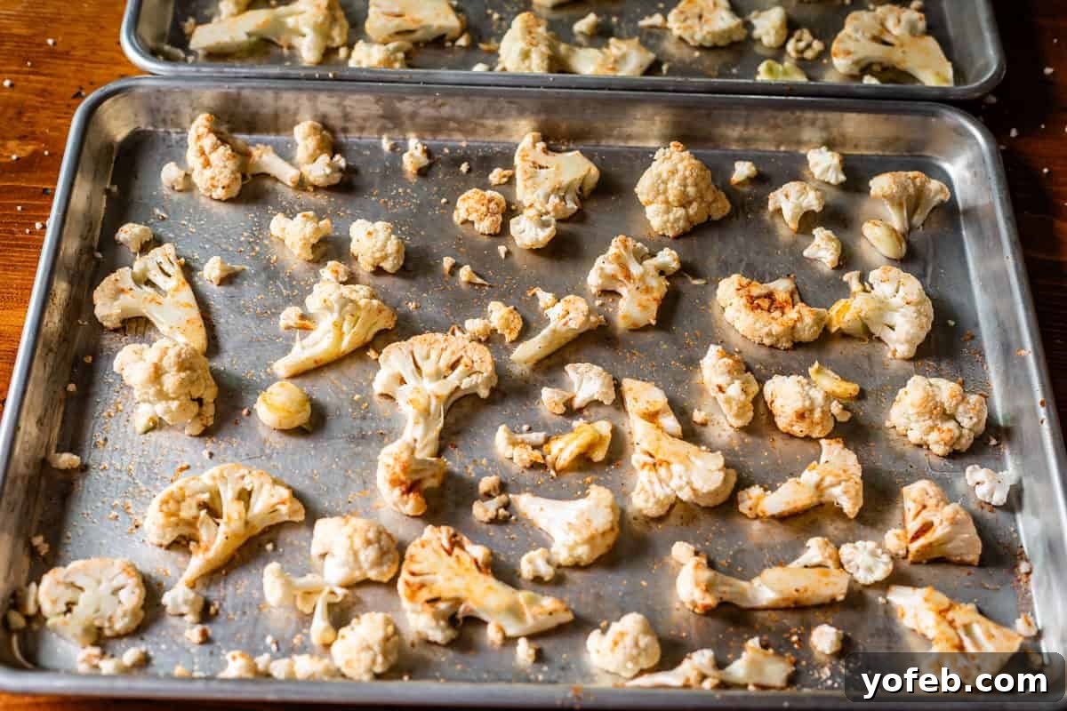 Perfectly Golden and Crispy Roasted Cauliflower 14 seasoned cauliflower pieces very spread out over two sheet pans.