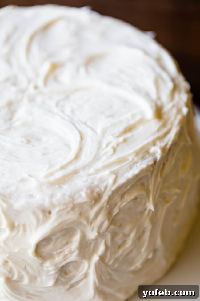 Elegant Swirls of Vanilla Frosting on White Cake A beautifully frosted, three-layer homemade white cake with swirled vanilla buttercream, ready to be enjoyed.