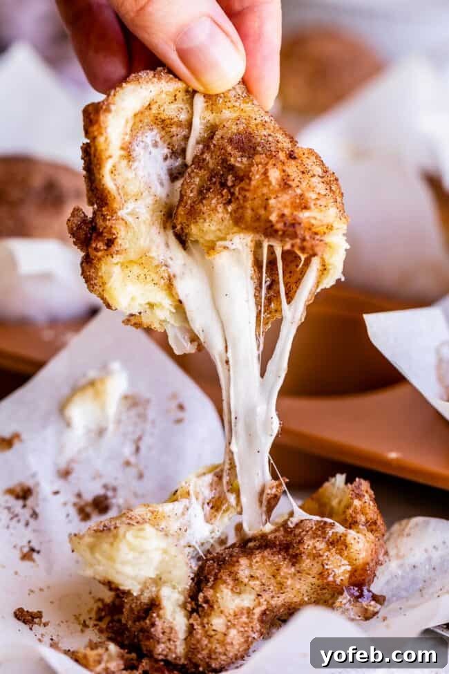 The irresistible, stretchy caramel from a baked Empty Tomb Roll. A close-up shot of a baked Empty Tomb Roll, broken open to reveal the long, stretchy, melted caramel marshmallow inside.