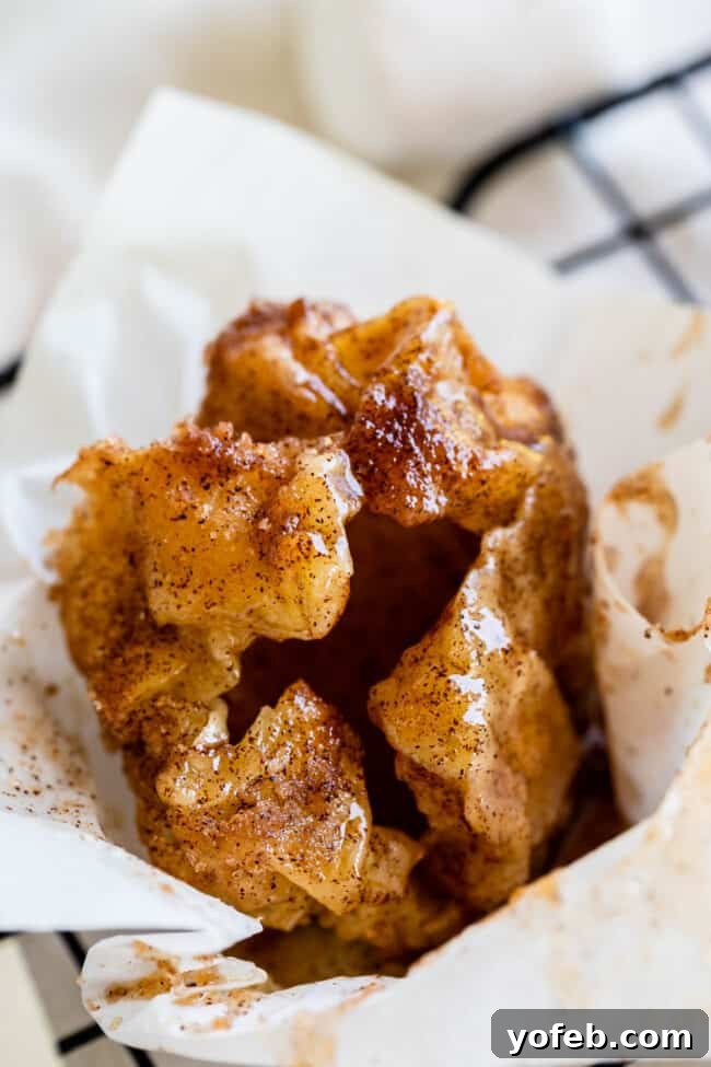 A basket of warm, freshly baked Empty Tomb Rolls, ready for an Easter celebration. A basket filled with freshly baked Empty Tomb Rolls (Resurrection Rolls), glistening with a cinnamon sugar glaze, invitingly presented.