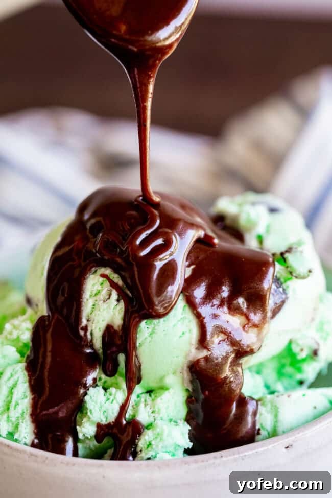 Easy Homemade Chocolate Sauce 4 Rich, homemade chocolate sauce cascades off a wooden spoon back into a gleaming pot, showcasing its perfect consistency.