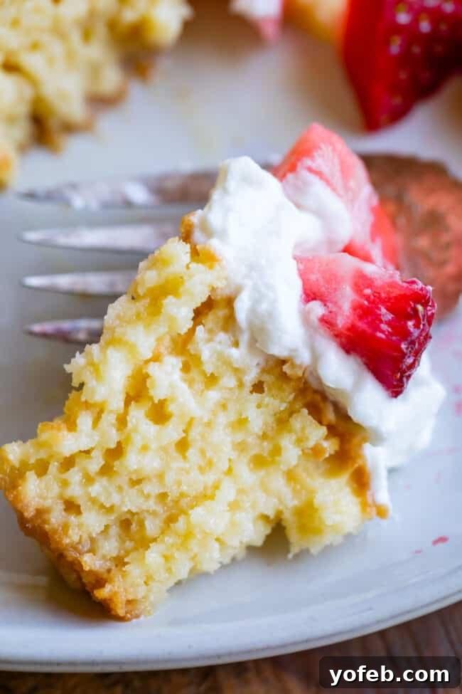 Ultimate Tres Leches Perfection 5 a bite of tres leches cake with strawberries on top.