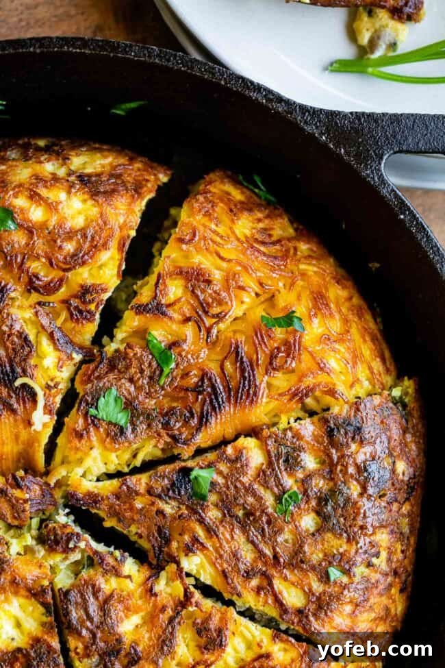 Easy 30-Minute Pasta Frittata with Sausage and Parmesan from The Food Charlatan. This dinner is done in 30 minutes and is so easy! The best part is that it uses mostly pantry ingredients (and sausage that you can freeze) so it's a good one to make when you haven't been shopping in a while! Swap out the veggies for whatever you have, and use leftover pasta if you have it! #leftoverspaghetti #recipes #dinners #eggs #cheese #Meals #brunch #dishes #breakfastrecipes #leftover #oliveoil #vegetables pasta frittata - a slice of golden-brown pasta frittata with sausage and parmesan, showing its crispy edges and savory interior
