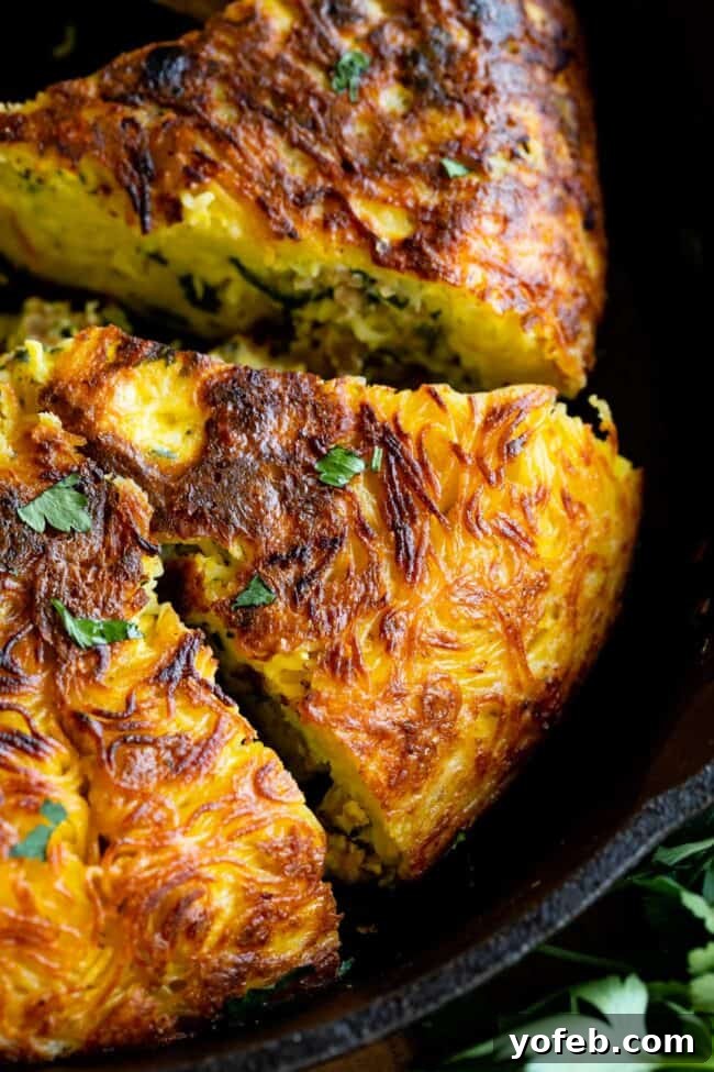 Easy 30-Minute Pasta Frittata with Sausage and Parmesan from The Food Charlatan. This dinner is done in 30 minutes and is so easy! The best part is that it uses mostly pantry ingredients (and sausage that you can freeze) so it's a good one to make when you haven't been shopping in a while! Swap out the veggies for whatever you have, and use leftover pasta if you have it! #leftoverspaghetti #recipes #dinners #eggs #cheese #Meals #brunch #dishes #breakfastrecipes #leftover #oliveoil #vegetables pasta frittata - a beautifully presented slice of pasta frittata on a white plate, garnished with fresh parsley