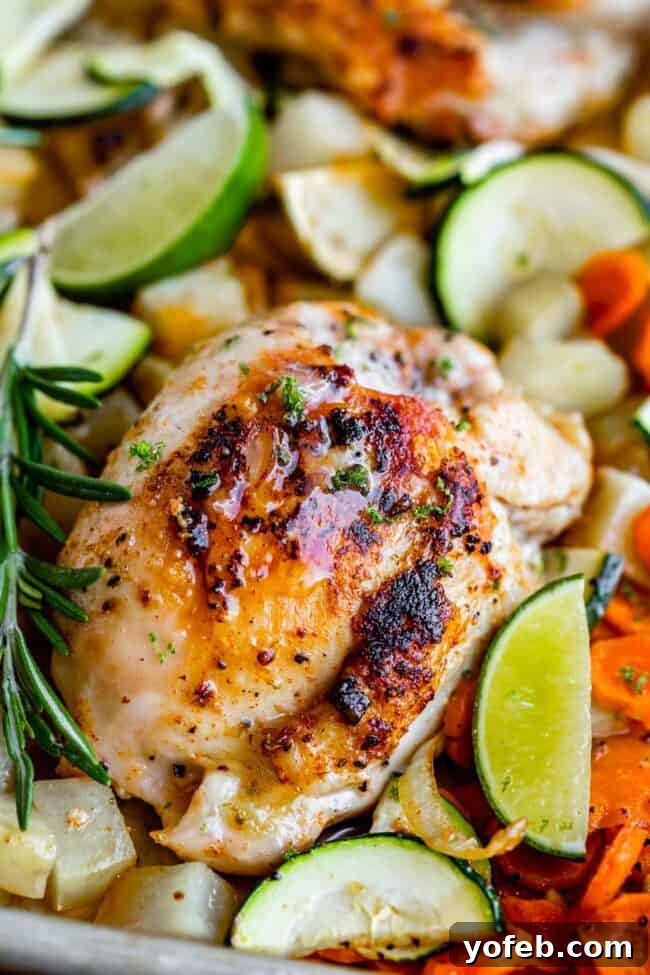 Sheet Pan Rosemary Lime Chicken and Veggies Golden-brown sheet pan rosemary lime chicken thighs with roasted potatoes, carrots, and zucchini, garnished with fresh rosemary sprigs and lime wedges.