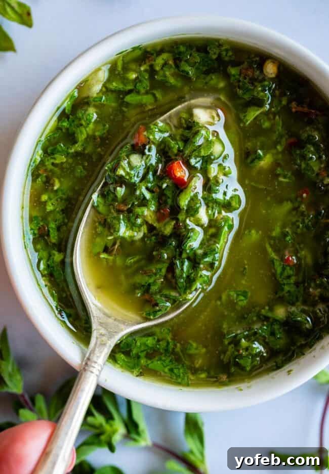 Fresh and Zesty Chimichurri Sauce - A versatile condiment that brightens any dish. A close-up shot of vibrant green chimichurri sauce, showing off its fresh, finely chopped ingredients and glistening olive oil.