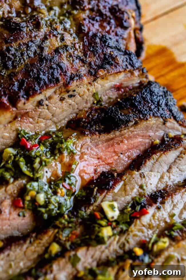 close up of tender flank steak broiled on top with herbs