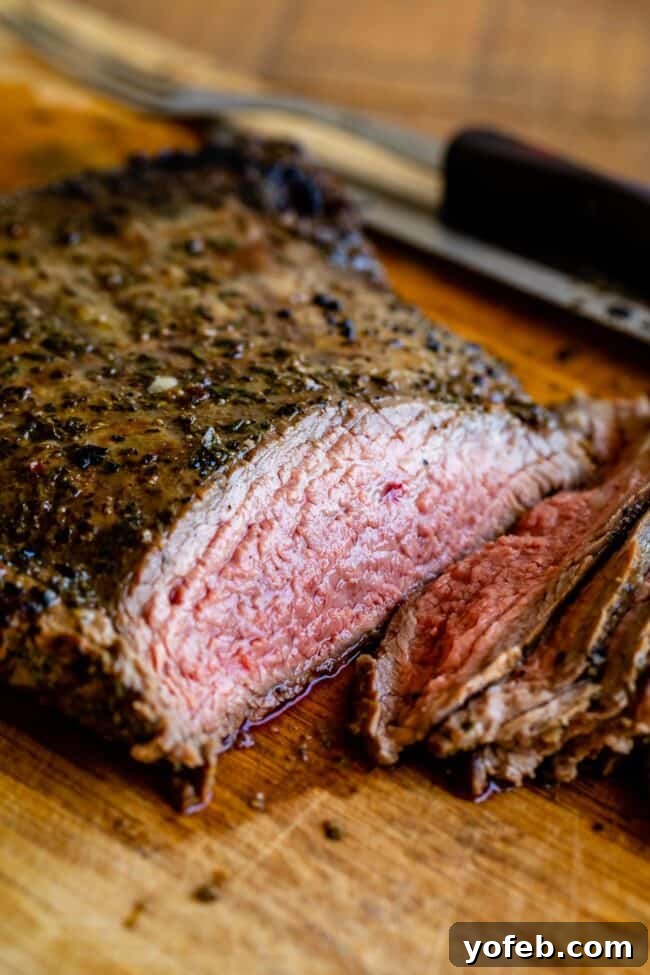 How to Cook Flank Steak (Grilled or Oven Broiled) Grilled flank steak, freshly sliced on a wooden cutting board, with various grilling tools nearby.