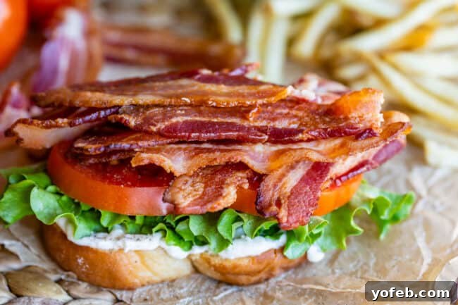 Crafting the Flawless BLT 12 bacon, tomato, lettuce, mayo, white bread, with fries in the background
