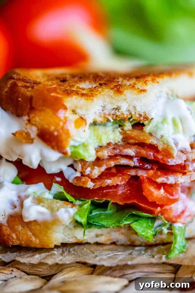 Crafting the Flawless BLT 4 BLT sandwich with toasted bread and mayo, with a bite taken out