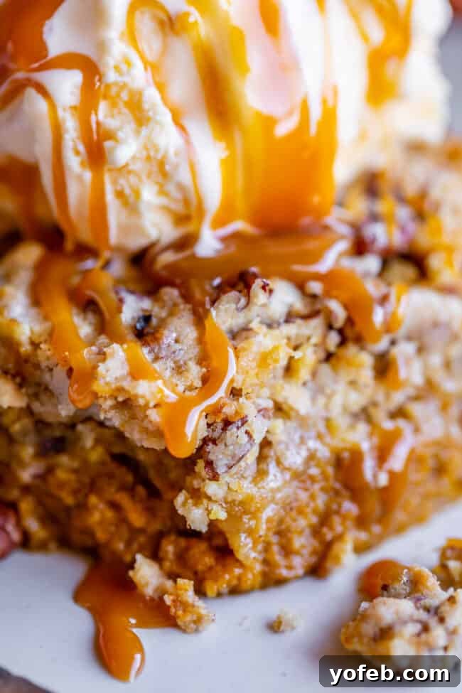 Simple Pumpkin Dump Cake: A delightful fall dessert featuring a rich pumpkin base and a crisp, buttery cake mix topping, enhanced with caramel. A close-up of a slice of pumpkin pie dump cake, generously drizzled with rich caramel sauce.
