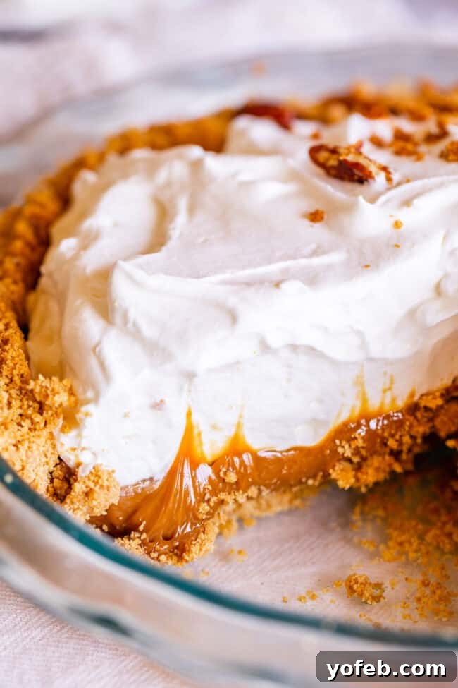 Dulce de Leche Pie: Easy Elegance for Your Dessert Table A whole Dulce de Leche Cream Pie, elegantly topped with whipped cream and pecan-graham crumble, sliced and ready to serve, perfect for a festive dessert table.