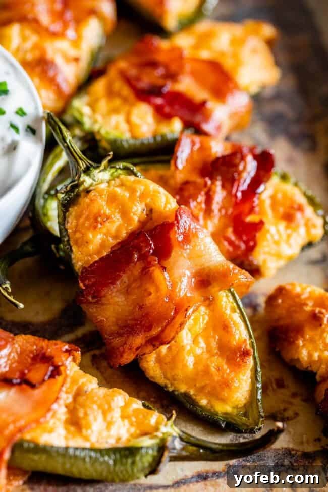 Baked Jalapeño Poppers: A Crispy, Cheesy Delight Close-up of perfectly baked bacon-wrapped jalapeño poppers, showing their golden-brown bacon and bubbling cheese filling.