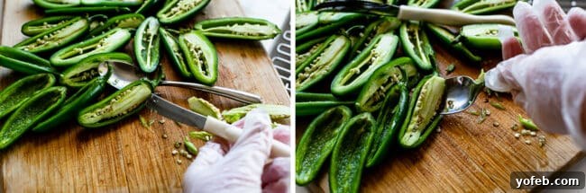 Safely Removing Jalapeño Seeds with Gloves Hands wearing disposable gloves meticulously removing the membrane and seeds from a sliced jalapeño with a spoon.
