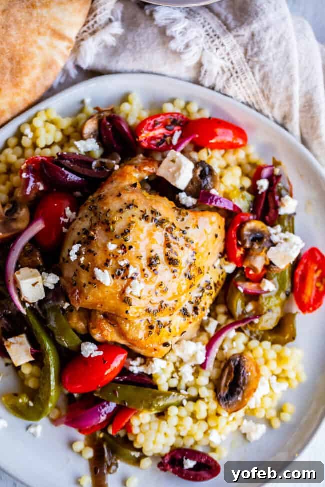 One-Pan Zesty Greek Chicken and Roasted Vegetables 3 Close-up of seared Greek chicken thighs and colorful vegetables, including bell peppers, red onions, mushrooms, and cherry tomatoes, ready for baking in a skillet.