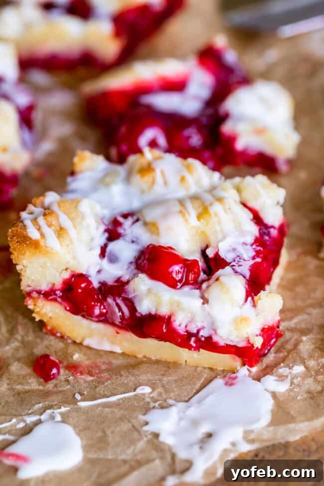 Overhead view of cherry pie bars cooling on a rack after baking, with a sprinkle of powdered sugar for presentation.