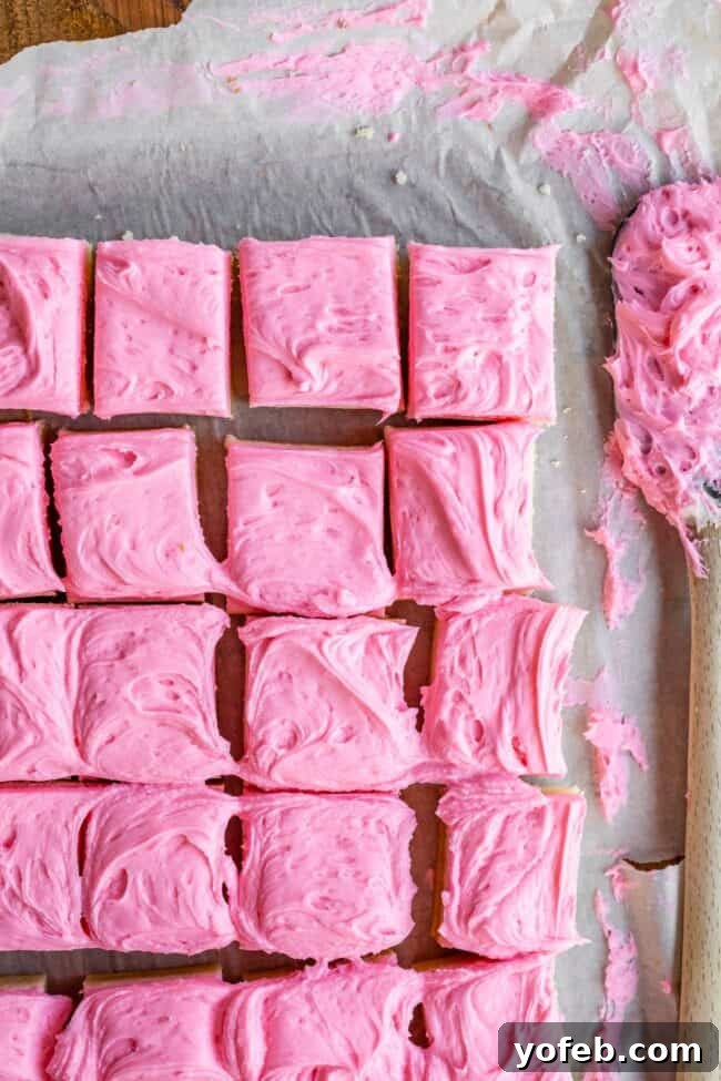 Soft and Chewy Sugar Cookie Bars from The Food Charlatan. These soft and chewy Sugar Cookie Bars are the stuff of dreams!! Adapted from my all time favorite soft sugar cookie recipe, these bars have a secret ingredient that make them supremely chewy. The thick layer of buttercream frosting on top makes them irresistible! #sugar #sugarcookie #bars #cookiebars #easy #recipe #withfrosting #best #buttercream #valentines #cookie #soft #chewy #icing #frosting sugar cookie bars on a plate with pink frosting
