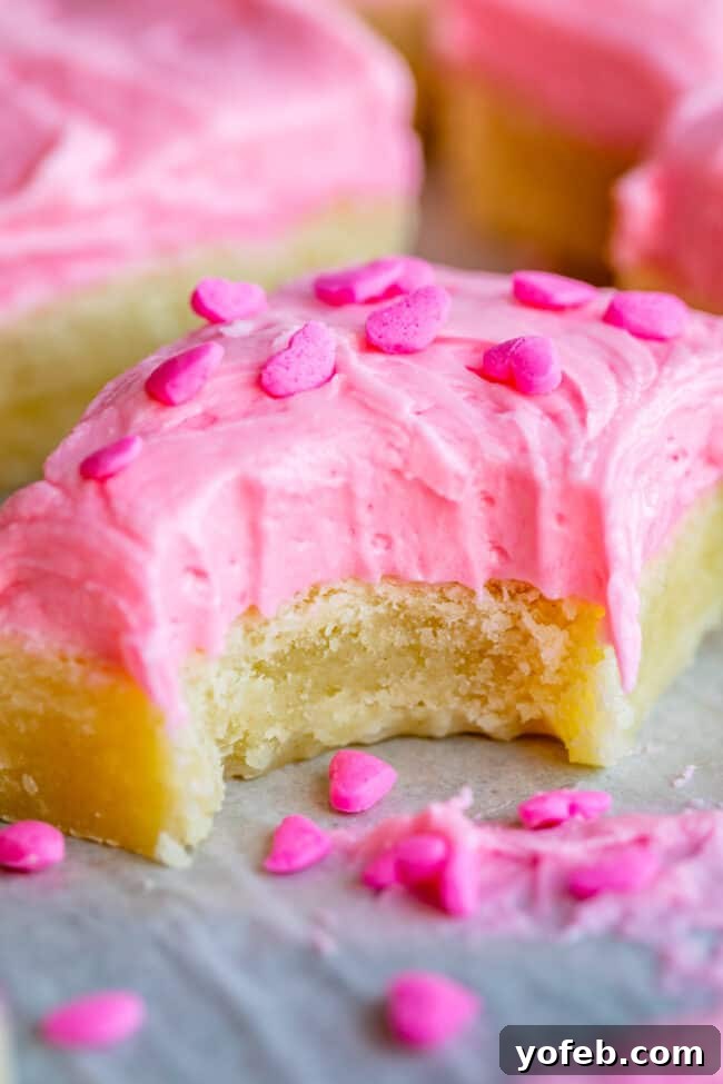 Soft and Chewy Sugar Cookie Bars from The Food Charlatan. These soft and chewy Sugar Cookie Bars are the stuff of dreams!! Adapted from my all time favorite soft sugar cookie recipe, these bars have a secret ingredient that make them supremely chewy. The thick layer of buttercream frosting on top makes them irresistible! #sugar #sugarcookie #bars #cookiebars #easy #recipe #withfrosting #best #buttercream #valentines #cookie #soft #chewy #icing #frosting sugar cookie bars recipe - perfect soft and chewy texture