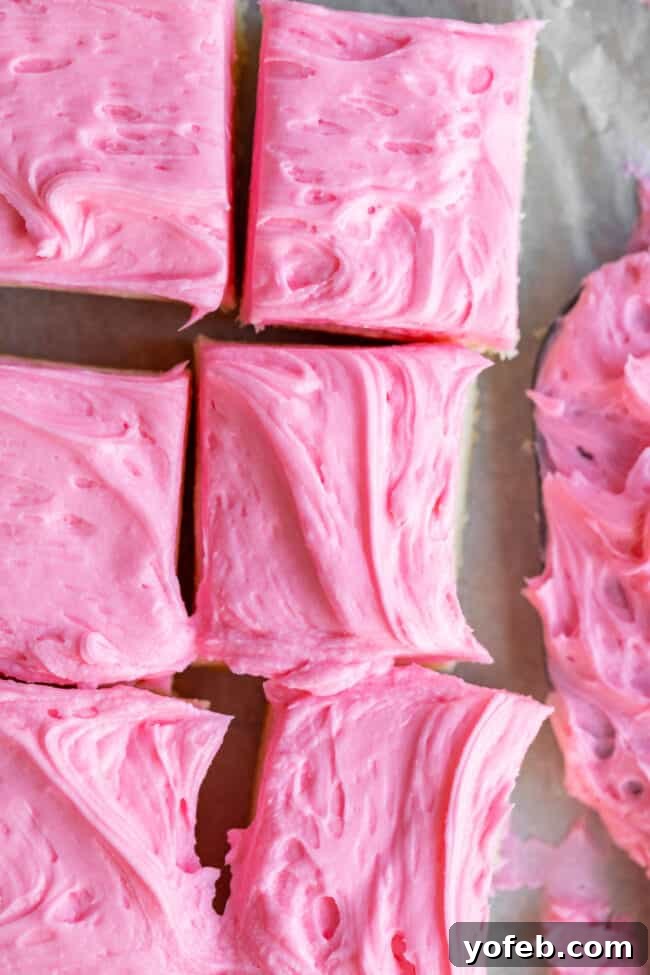 Soft and Chewy Sugar Cookie Bars from The Food Charlatan. These soft and chewy Sugar Cookie Bars are the stuff of dreams!! Adapted from my all time favorite soft sugar cookie recipe, these bars have a secret ingredient that make them supremely chewy. The thick layer of buttercream frosting on top makes them irresistible! #sugar #sugarcookie #bars #cookiebars #easy #recipe #withfrosting #best #buttercream #valentines #cookie #soft #chewy #icing #frosting sugar cookie bars - closeup of a festive frosted bar