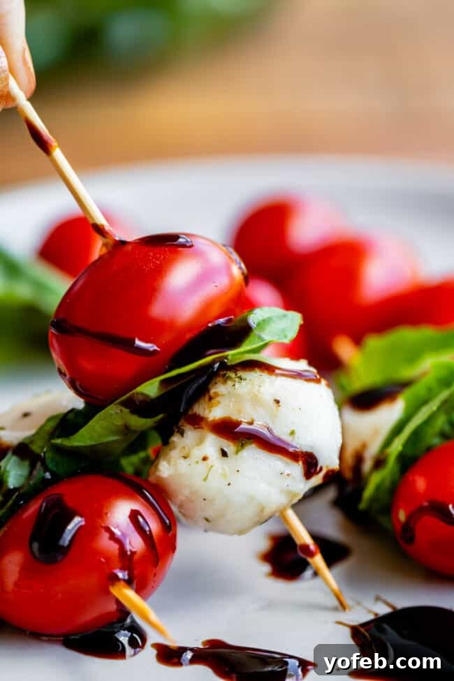 Tomato Mozzarella Basil Skewers A platter of stunning tomato, mozzarella, and basil skewers, ready to be enjoyed as a light and flavorful appetizer.