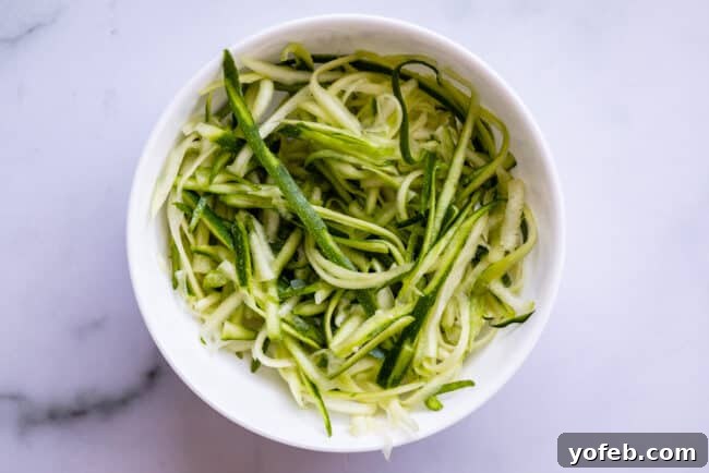 Spiralizer-Free Zucchini Noodles 15 A white bowl featuring straight zucchini noodles, showcasing a simple, clean presentation on a kitchen counter.