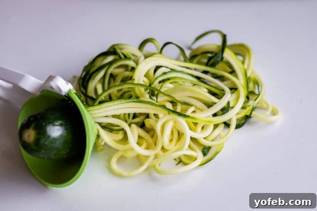 Spiralizer-Free Zucchini Noodles 10 A zucchini being twisted into a handheld spiralizer, demonstrating the simple, effective motion.